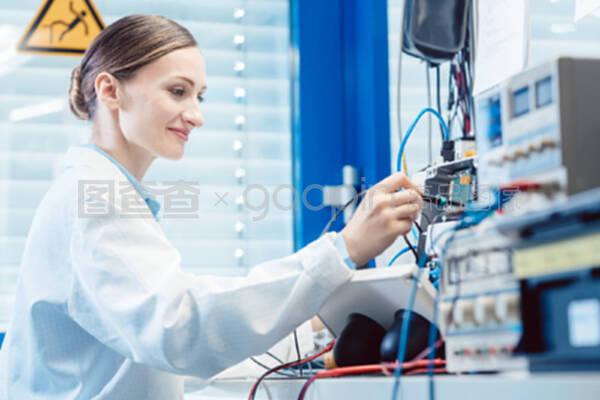 在試驗臺上測量電子產品的工程師